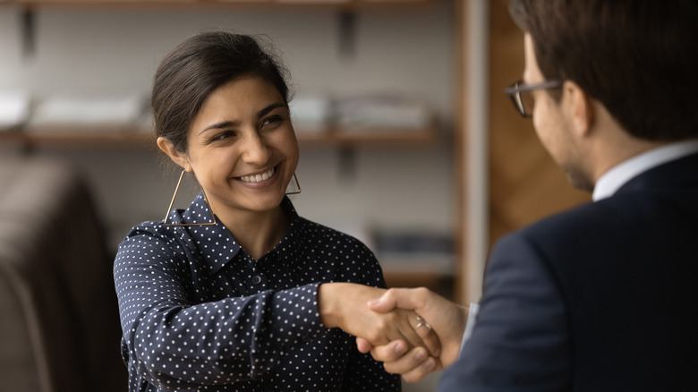 A woman shaking a man's hand