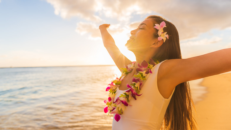Woman wearing a lei on a beach in Hawaii