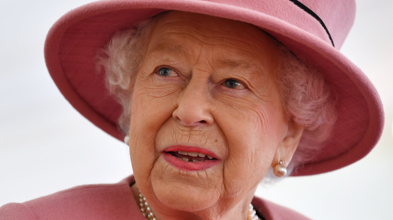 Queen Elizabeth smiling in pink hat