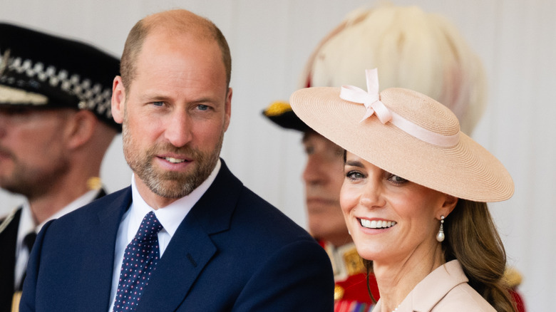 Prince William smiling next to Princess Kate.