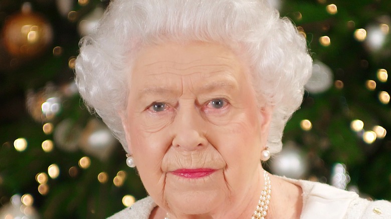 Queen Elizabeth posing in front of Christmas tree