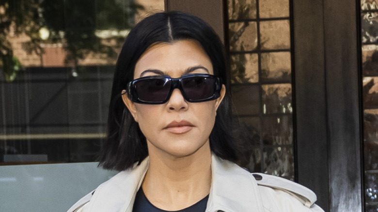 Kourtney Kardashian walking on the sidewalk with Travis Barker