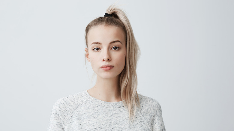 Young woman wearing her light blonde hair in a high pony tail