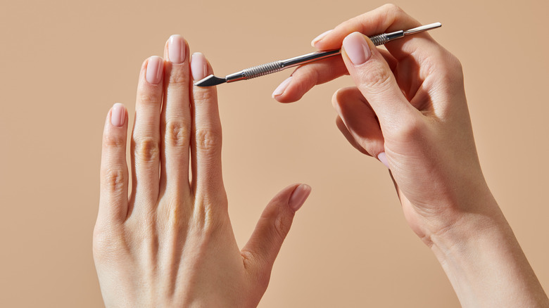 Woman using cuticle pusher