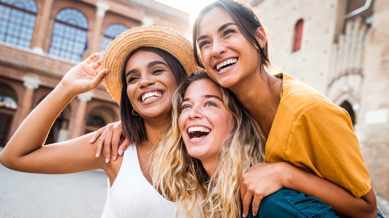 Three women smiling and hugging each other