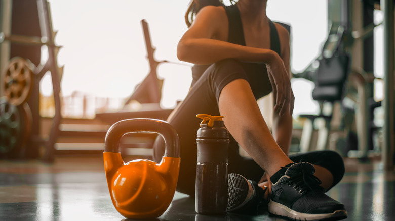 Woman at a gym with a kettlebell and water bottle