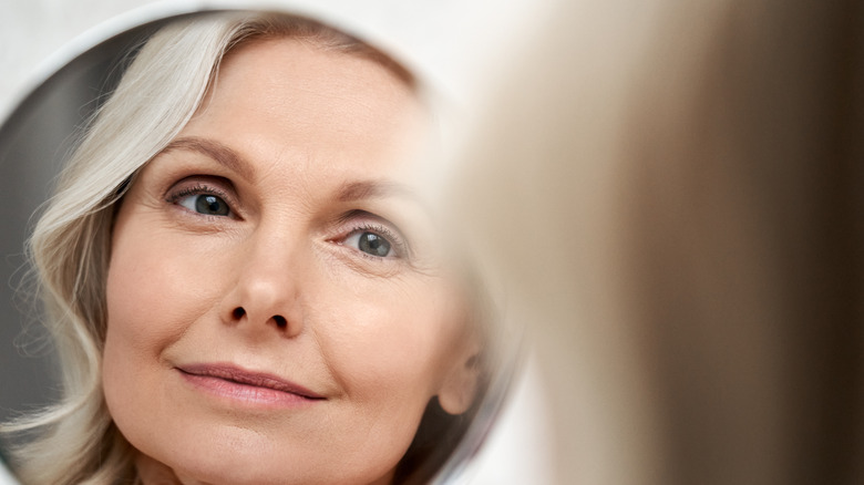 Middle-aged woman looking in mirror