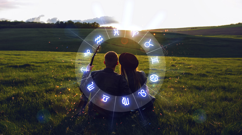 Couple sitting together under zodiac wheel