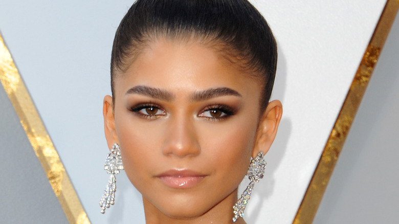 Close-up of Zendaya wearing dangling diamond earrings and gold eyeshadow