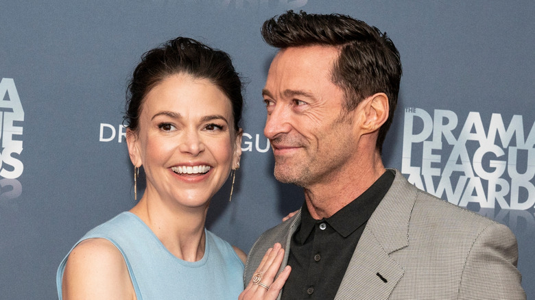 Sutton Foster wearing a light blue dress touching Hugh Jackman's chest at the Annual Drama League awards.