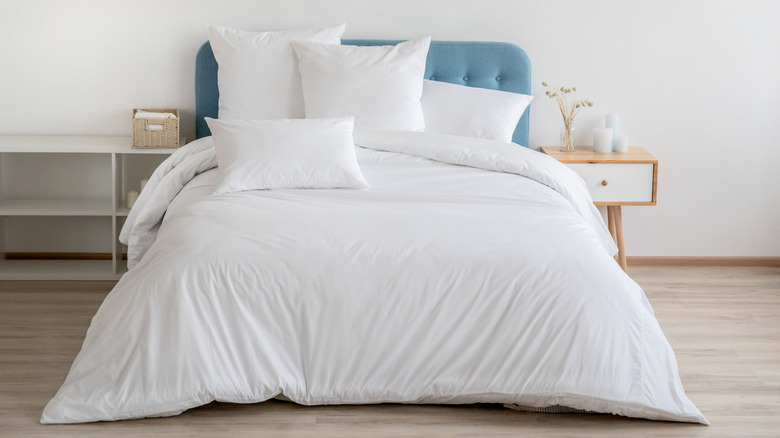 A bed with all-white bedding.