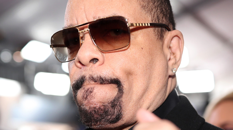 Ice-T holds up his fist on the red carpet