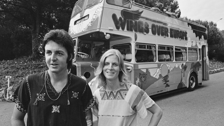 Paul and Linda McCartney pose next to their tour bus