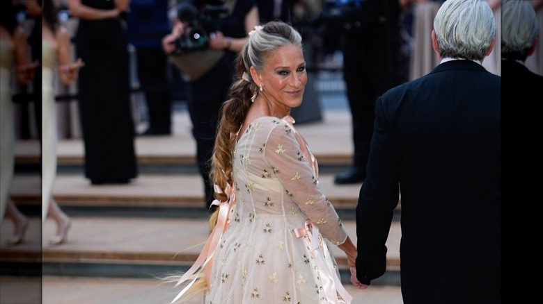 Sarah Jessica Parker looking back and smiling while walking with Matthew Broderick