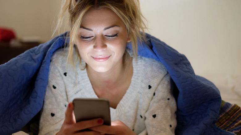 blonde woman smiling at phone