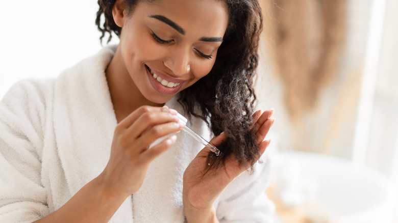 Woman applying oil to hair