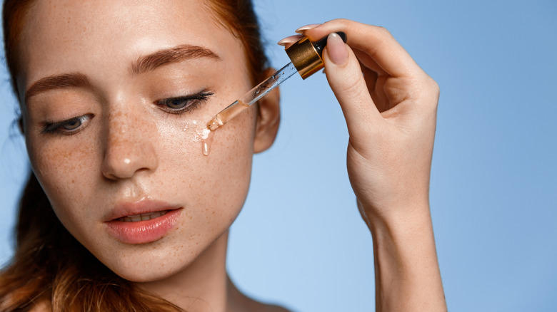 Woman applying oil on face