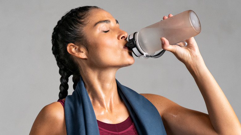 Woman drinking water from reusable bottle