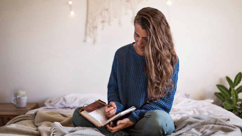 Woman journaling in bed