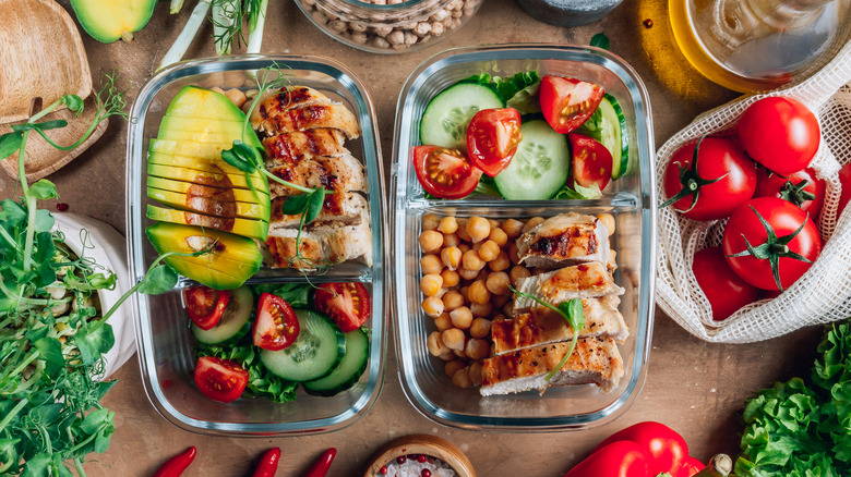 Healthy meal prep containers with greens, poultry, and avocado
