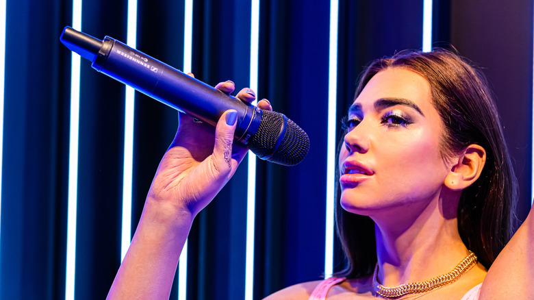 Dua Lipa holding a microphone