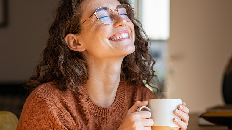 Woman joyfully drinking coffee