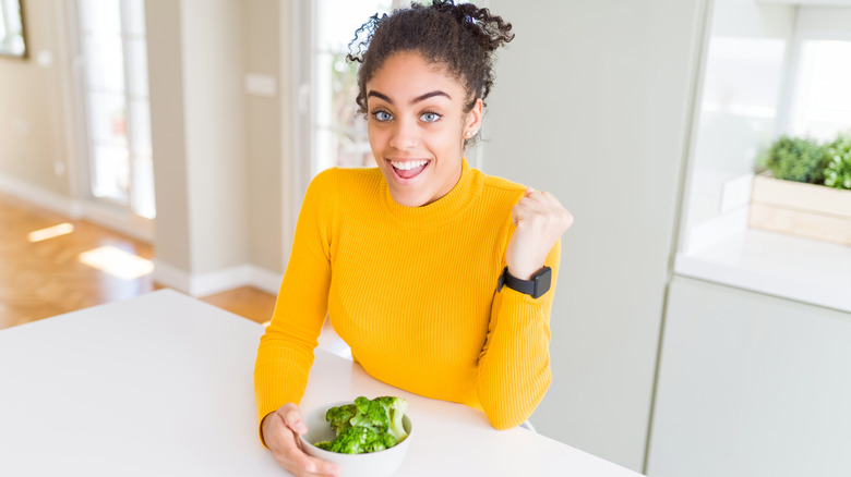 Woman looking excited about broccoli
