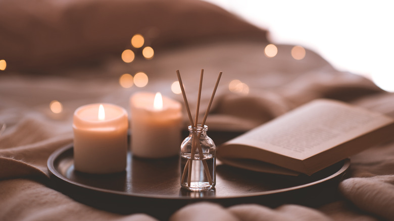 books on a bed with candles