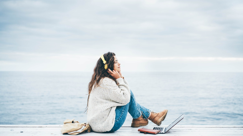 a woman listening to music on a beach