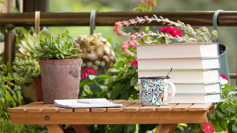 books stacked on table with mug