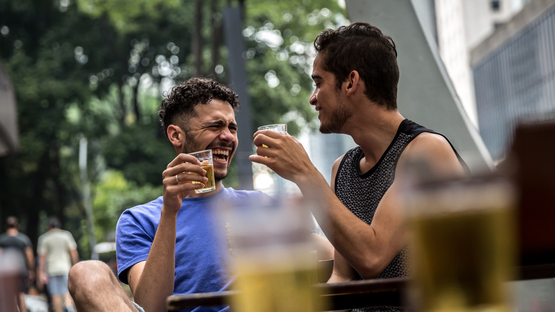 two people drinking beer and laughing together 