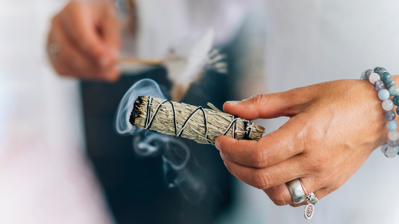 woman holding sage smudge stick