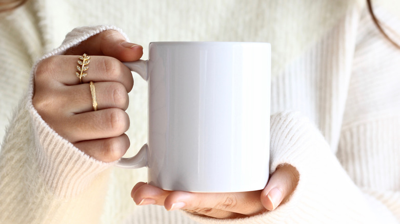 Woman holding a white mug