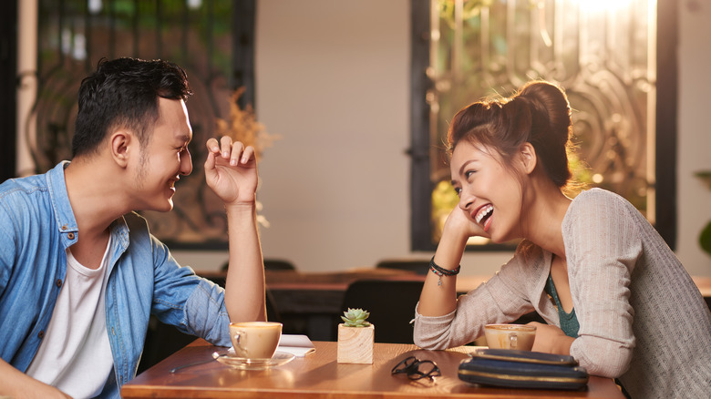 Couple on a first date laughing over coffee