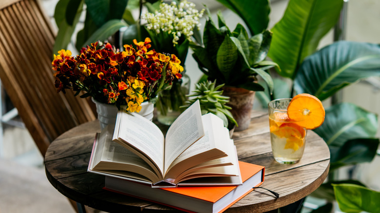 books stacked on a table with fresh flowers 