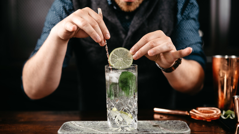 Bartender making gin and tonic