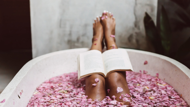 book on a woman's legs in a tub