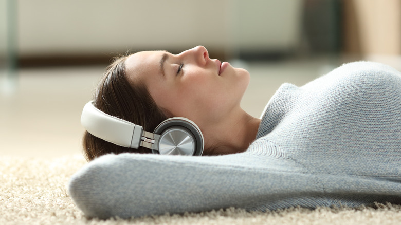 Woman lying on floor with headphones