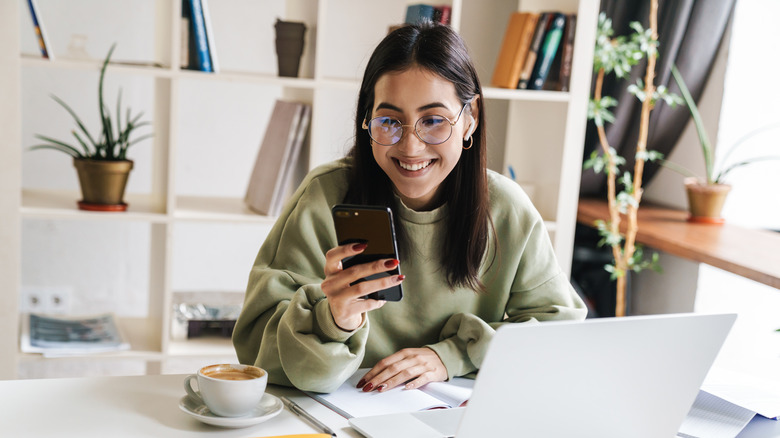A woman smiling at her phone