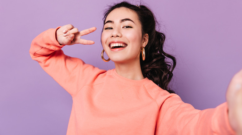 A woman giving a peace sign