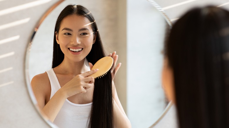 girl brushing her hair in the mirror