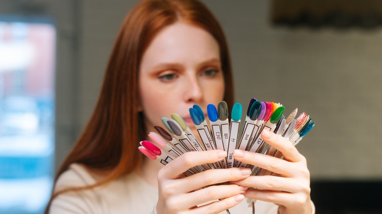 woman looking at nail polish samples