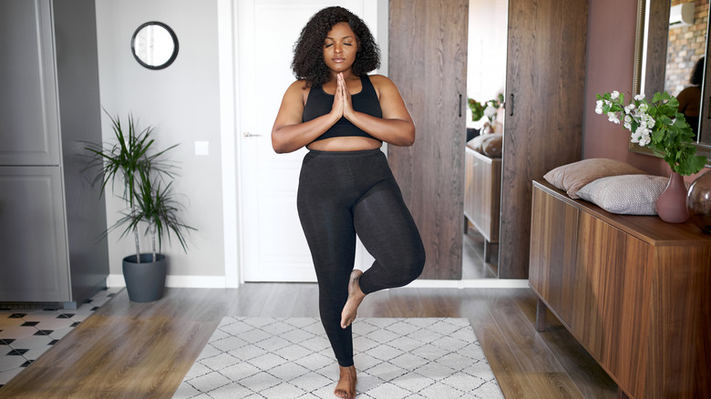 woman doing yoga in her living room