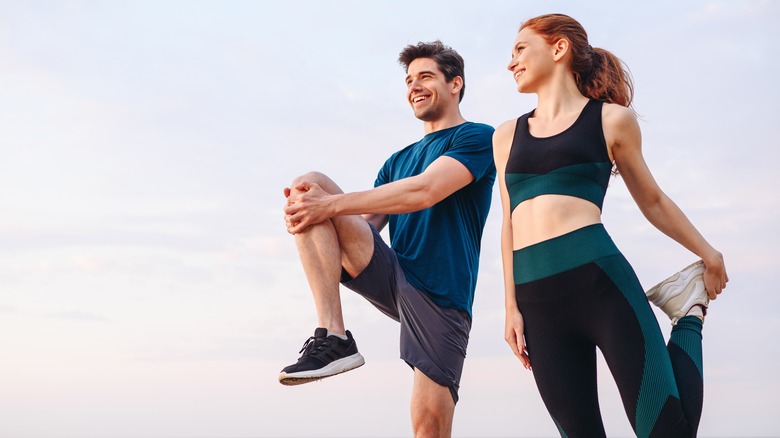 man and woman stretching before a run