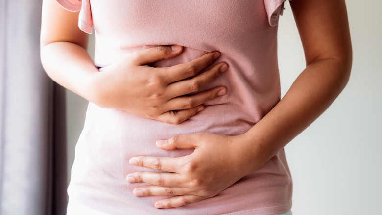 Woman holding her stomach in discomfort 