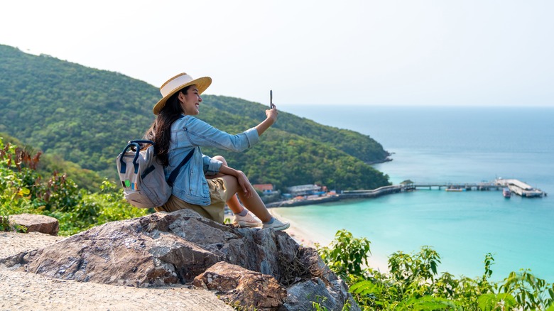 Woman takes photo from cliff