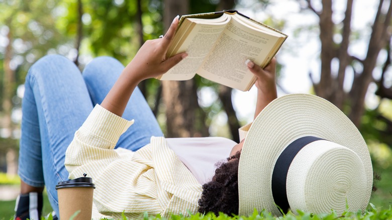 woman lying in grass reading