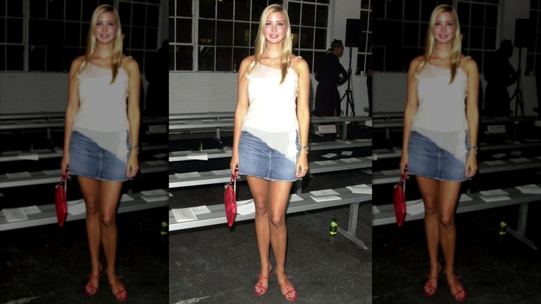 Ivanka Trump poses for a photo at a 2002 New York Fashion Week show wearing a white top and denim skirt