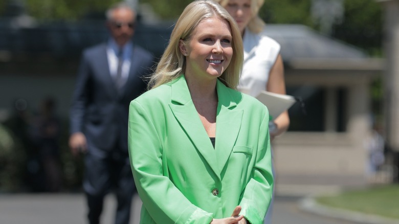 Karoline Leavitt pictured with another blonde woman behind her, wearing a hugely oversized green blazer