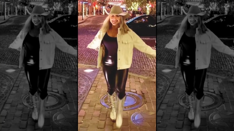 Still from video of Karoline Leavitt in Texas in 2023 as she's pictured in black leather pants, black top, white cowboy jacket and cowboy hat, and white cowboy boots